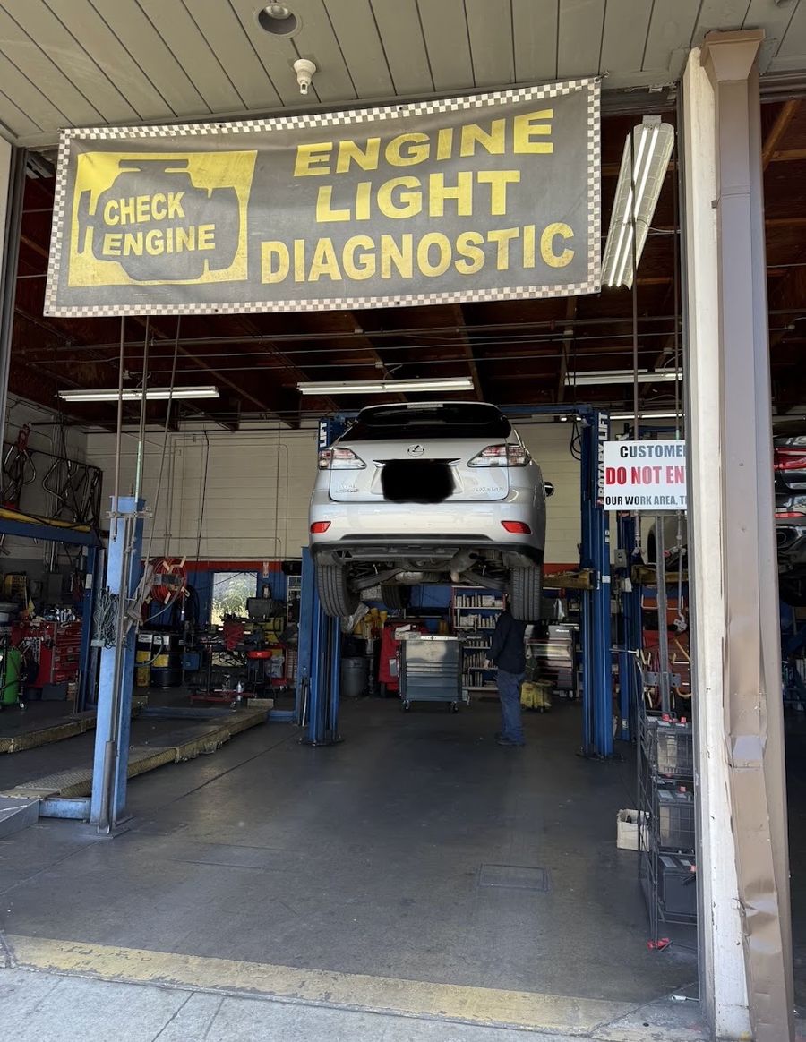 Petro&rsquo;s service bay with a car on the lift under the Engine Light Diagnostic sign